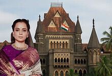 Indian woman in traditional saree in front of historic Mumbai court building.