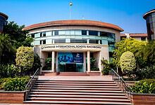 Oakridge International School Gachibowli building with lush greenery and clear blue sky.