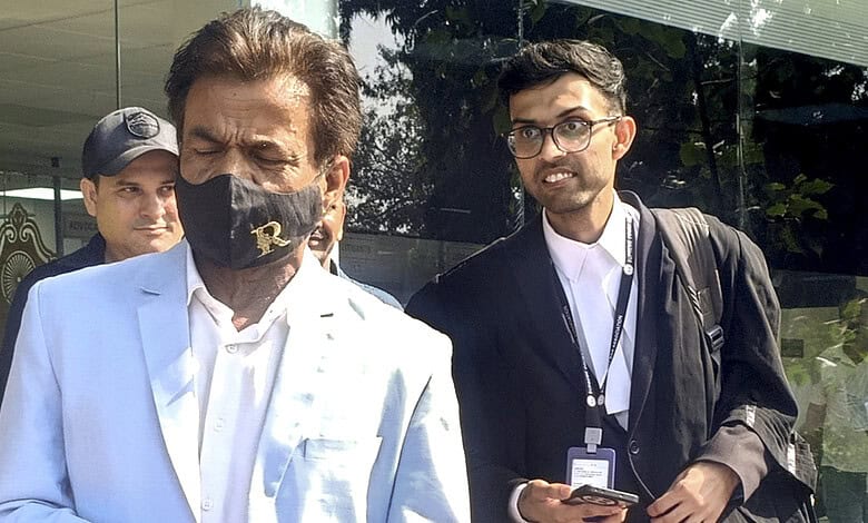 Rajpal Yadav and a man in a suit outside a building, engaged in conversation.