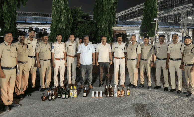 RPF officers display seized liquor bottles at Kachiguda railway station during checks.