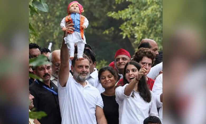 Indian politician Rahul Gandhi holding a doll during a public gathering or rally.