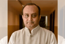 Indian man in traditional attire with a neutral expression, indoor setting.