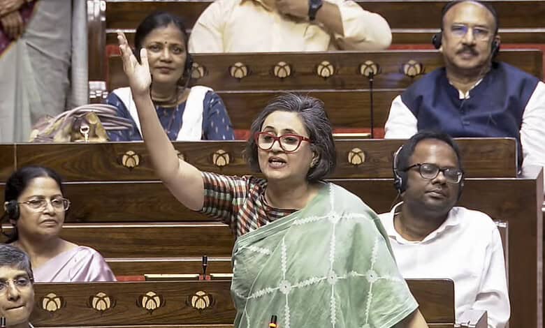 Indian woman speaking passionately in a parliamentary session with colleagues.