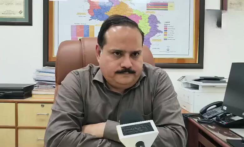 UP CEO seated at desk with map of India in background, serious expression.