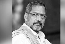 Black and white portrait of Nana Patekar with glasses and a beard.