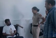 Delhi Police officers interrogate a man with a bloodstained shirt in a police station.