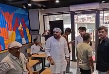 Group of people inside Domino's restaurant with some waiting and others ordering food.