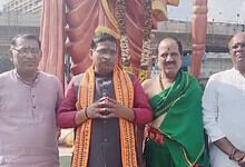 Group of four men standing in front of a large statue during a public event in Basheer Bagh.