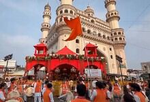 Charminar decorated with red banners and flags during a festival or event.