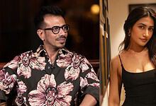 Yuzvendra Chahal and a woman at a social gathering, smiling and posing for the camera.