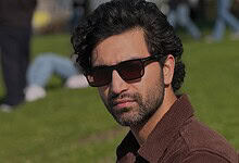 Pakistani actor Ahad Raza Mir wearing sunglasses outdoors in a park setting.