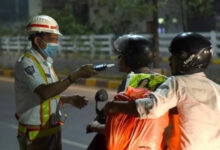 Traffic police officer checks documents of motorcyclists on a city street at night.