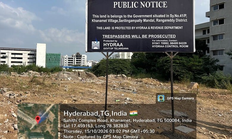 Public notice on land protection in Hyderabad, India, with city buildings in the background.