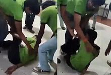 People rescuing a person trapped under a green bag at Siasat Daily office.