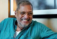 Nana Patekar smiling in a casual setting with glasses and a turquoise shirt.
