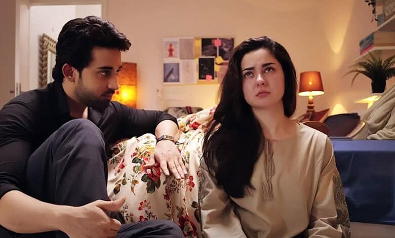 Pakistani drama scene with a man and woman in a living room setting.