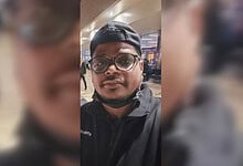 Man wearing glasses and cap at Riyadh airport, critically injured, in a selfie.